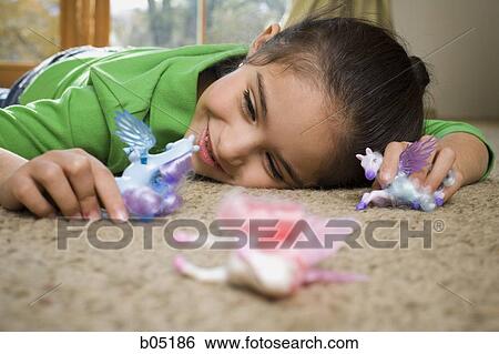 Young girl playing with toys on carpet View Large Photo Image Stock Photograph - Young girl playing with toys on carpet. Fotosearch