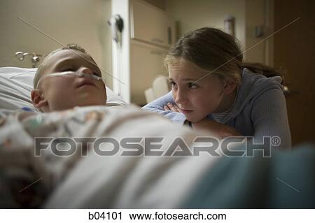Young girl sitting by brother in hospital bed View Large Photo Image Stock Image - Young girl sitting by brother in hospital bed. Fotosearch