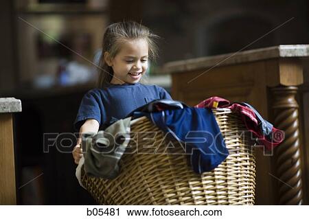 Stock Image - Young girl with laundry basket. Fotosearch