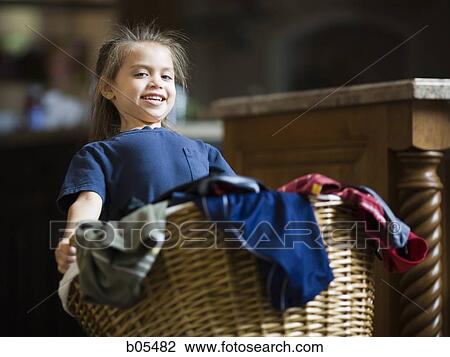 Stock Image - Young girl with laundry basket. Fotosearch