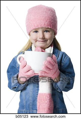 Stock Image - Young girl with pink hat and gloves holding mug. Fotosearch