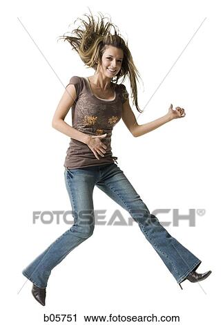 Stock Image - Young woman jumping and playing air guitar. Fotosearch