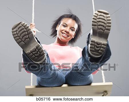 Young woman on a swing View Large Photo Image Stock Photograph - Young woman on a swing. Fotosearch