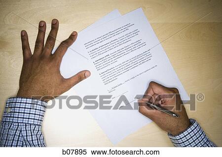 Stock Photography - African-American man signing paperwork. Fotosearch