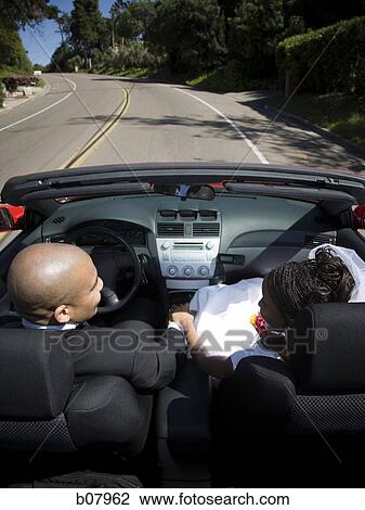 Stock Image - African-American newlywed couple in convertible car. Fotosearch