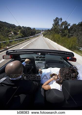 Stock Image - African-American newlywed couple in convertible car. Fotosearch