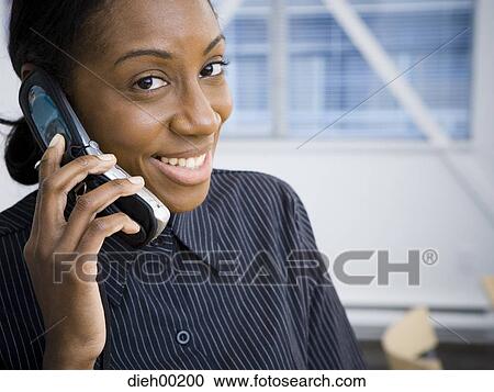 Stock Image - African-American woman talking on phone. Fotosearch