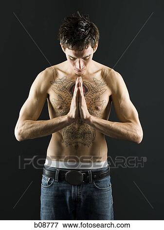 Bare chested young man standing with head bowed View Large Photo Image Stock Photo - Bare chested young man standing with head bowed. Fotosearch