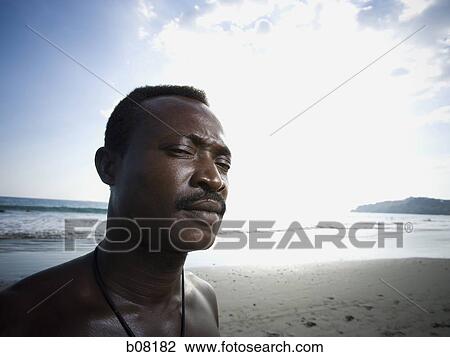 Black male posing for portrait on beach View Large Photo Image Stock Image - Black male posing for portrait on beach. Fotosearch