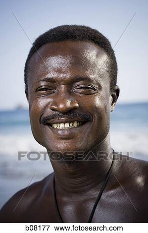 Stock Photo - Black male posing for portrait on beach. Fotosearch