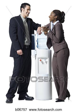 Business people conversing at water cooler View Large Photo Image Stock Photo - Business people conversing at water cooler. Fotosearch