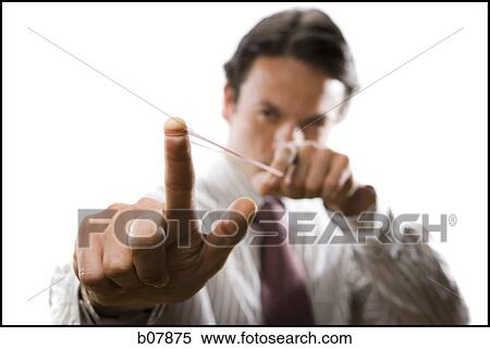 Businessman aiming to shoot a rubberband View Large Photo Image Stock Photography - Businessman aiming to shoot a rubberband. Fotosearch