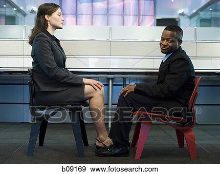 Businessman and a businesswoman sitting face to face View Large Photo Image Stock Photo - Businessman and a businesswoman sitting face to face. Fotosearch