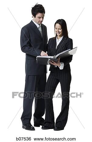 Stock Photograph - Businessman and businesswoman reviewing documents. Fotosearch