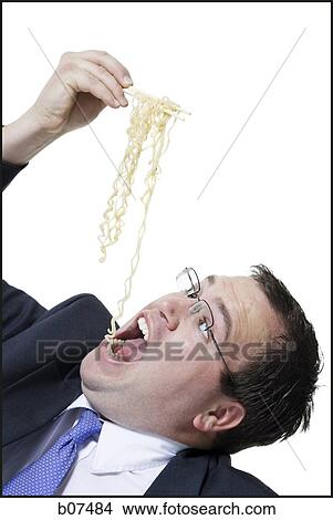Businessman awkwardly eating noodles View Large Photo Image Picture - Businessman awkwardly eating noodles. Fotosearch