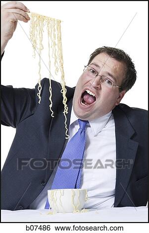 Businessman awkwardly eating noodles View Large Photo Image Stock Photograph - Businessman awkwardly eating noodles. Fotosearch