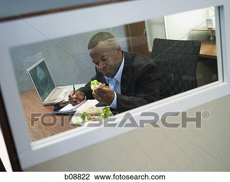 Businessman eating a salad at his desk View Large Photo Image Stock Image - Businessman eating a salad at his desk. Fotosearch