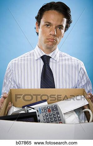 Businessman holding box of office property View Large Photo Image Stock Photography - Businessman holding box of office property. Fotosearch