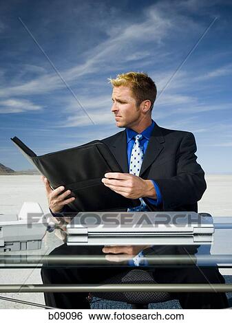 Businessman reading a file View Large Photo Image Stock Photograph - Businessman reading a file. Fotosearch