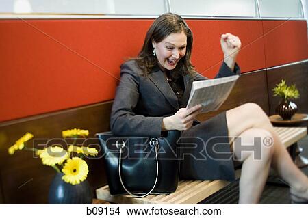 Picture - Businesswoman reading a newspaper. Fotosearch