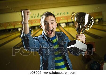 Champion bowler showing off trophy View Large Photo Image Stock Image - Champion bowler showing off trophy. Fotosearch