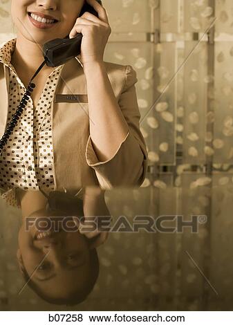 Check in counter attendant on the phone View Large Photo Image Stock Photo - Check in counter attendant on the phone. Fotosearch