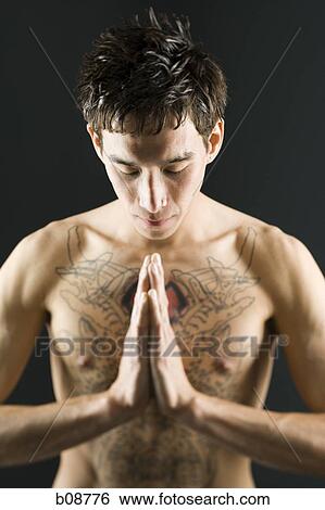 Close-up of a bare chested young man with head bowed View Large Photo Image Stock Photograph - Close-up of a bare chested young man with head bowed. Fotosearch