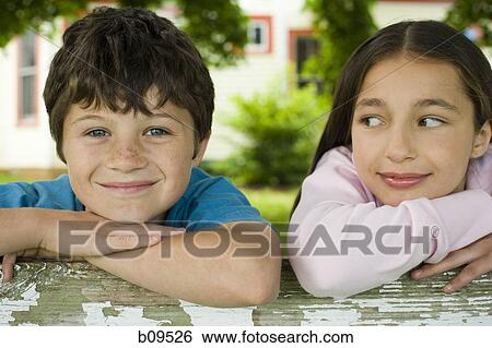 Close-up of a boy and a girl smiling View Large Photo Image Stock Photograph - Close-up of a boy and a girl smiling. Fotosearch