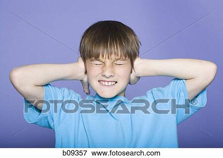 Close-up of a boy covering his ears View Large Photo Image Stock Photo - Close-up of a boy covering his ears. Fotosearch