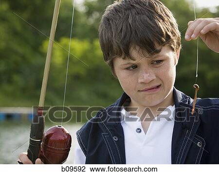 Close-up of a boy holding a fishing rod View Large Photo Image Stock Image - Close-up of a boy holding a fishing rod. Fotosearch