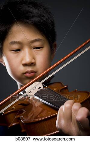Close-up of a boy playing the violin View Large Photo Image Stock Photo - Close-up of a boy playing the violin. Fotosearch