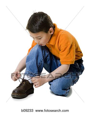 Close-up of a boy tying his shoelace View Large Photo Image Stock Image - Close-up of a boy tying his shoelace. Fotosearch