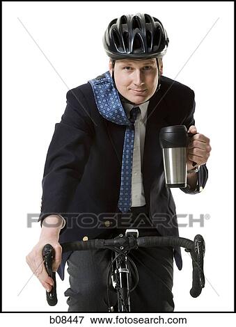 Stock Photo - Close-up of a businessman cycling with a mug in his hand. Fotosearch