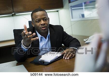 Close-up of a businessman discussing with his colleague View Large Photo Image Picture - Close-up of a businessman discussing with his colleague. Fotosearch