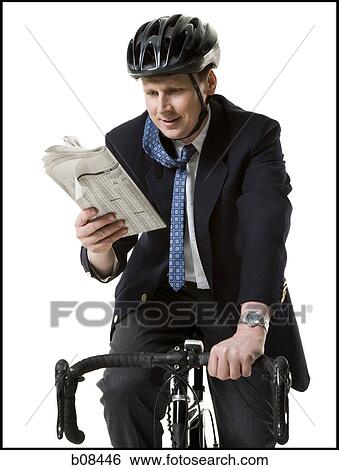 Close-up of a businessman reading a newspaper on a cycle View Large Photo Image Stock Photograph - Close-up of a businessman reading a newspaper on a cycle. Fotosearch