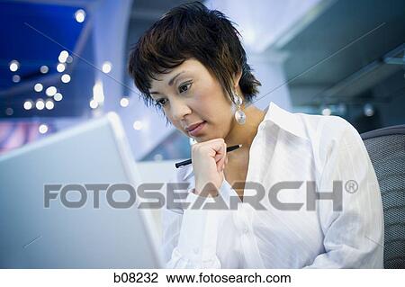 Close-up of a businesswoman in front of a laptop View Large Photo Image Stock Image - Close-up of a businesswoman in front of a laptop. Fotosearch