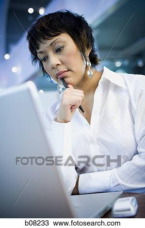 Close-up of a businesswoman in front of a laptop View Large Photo Image Stock Image - Close-up of a businesswoman in front of a laptop. Fotosearch