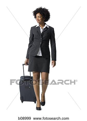 Close-up of a businesswoman walking with luggage View Large Photo Image Stock Photo - Close-up of a businesswoman walking with luggage. Fotosearch