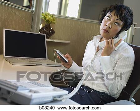 Close-up of a businesswoman with an MP3 player in her hand talking on the telephone View Large Photo Image Stock Image - Close-up of a businesswoman with an MP3 player in her hand talking on the telephone. Fotosearch