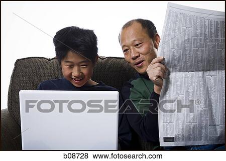Close-up of a father holding a newspaper and his son using a laptop View Large Photo Image Stock Photo - Close-up of a father holding a newspaper and his son using a laptop. Fotosearch