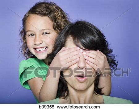 Close-up of a girl covering her mother's eyes View Large Photo Image Stock Photography - Close-up of a girl covering her mother's eyes. Fotosearch
