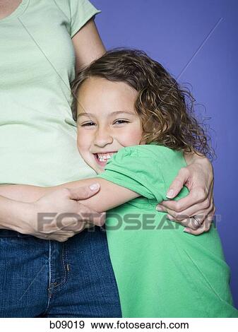 Close-up of a girl hugging her mother View Large Photo Image Stock Photo - Close-up of a girl hugging her mother. Fotosearch