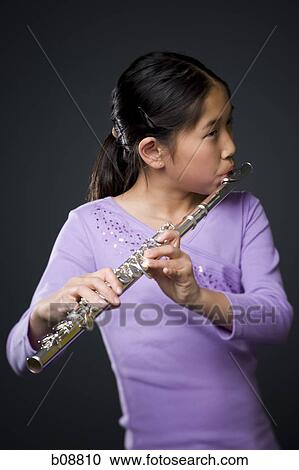 Stock Image - Close-up of a girl playing the flute. Fotosearch