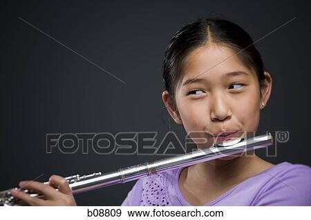 Close-up of a girl playing the flute View Large Photo Image Stock Photo - Close-up of a girl playing the flute. Fotosearch