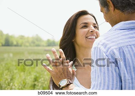 Close-up of a man and a woman holding hands in a field View Large Photo Image Picture - Close-up of a man and a woman holding hands in a field. Fotosearch