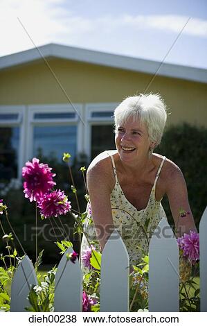 Stock Photo - Close-up of a mature woman gardening and smiling. Fotosearch
