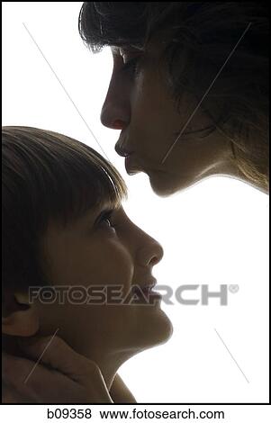 Close-up of a mid adult woman kissing her son's forehead View Large Photo Image Stock Photo - Close-up of a mid adult woman kissing her son's forehead. Fotosearch