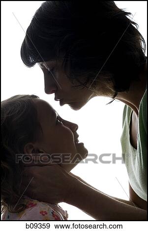 Close-up of a mid adult woman kissing her daughter's forehead View Large Photo Image Stock Photo - Close-up of a mid adult woman kissing her daughter's forehead. Fotosearch