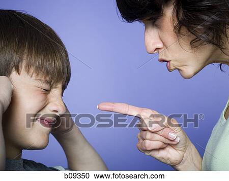 Stock Image - Close-up of a mid adult woman scolding her son. Fotosearch