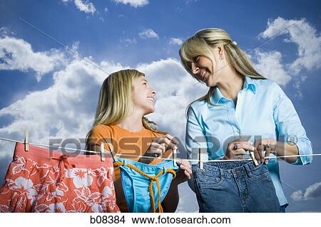 Close-up of a mother and her daughter looking at each other and smiling while doing laundry View Large Photo Image Picture - Close-up of a mother and her daughter looking at each other and smiling while doing laundry. Fotosearch